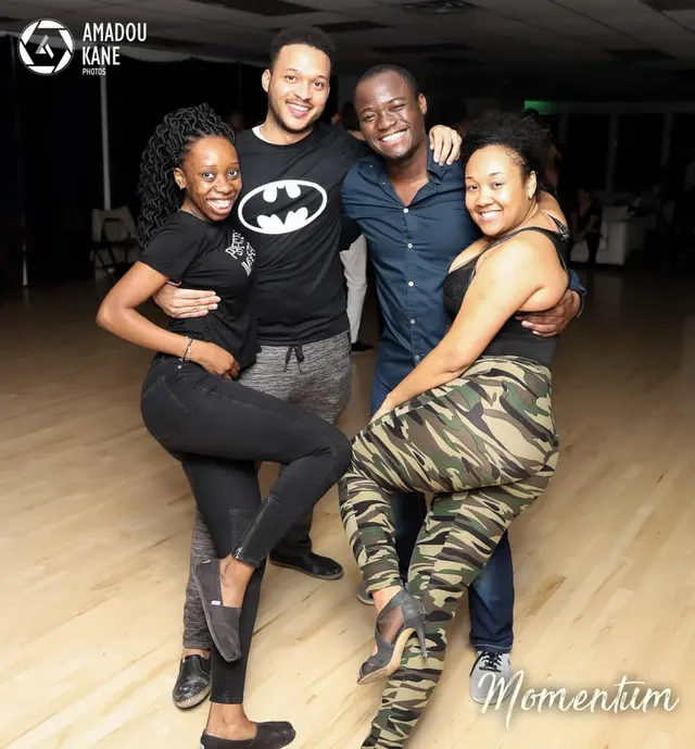 Four dancers, Baggio among them, posing together and laughing in a studio.