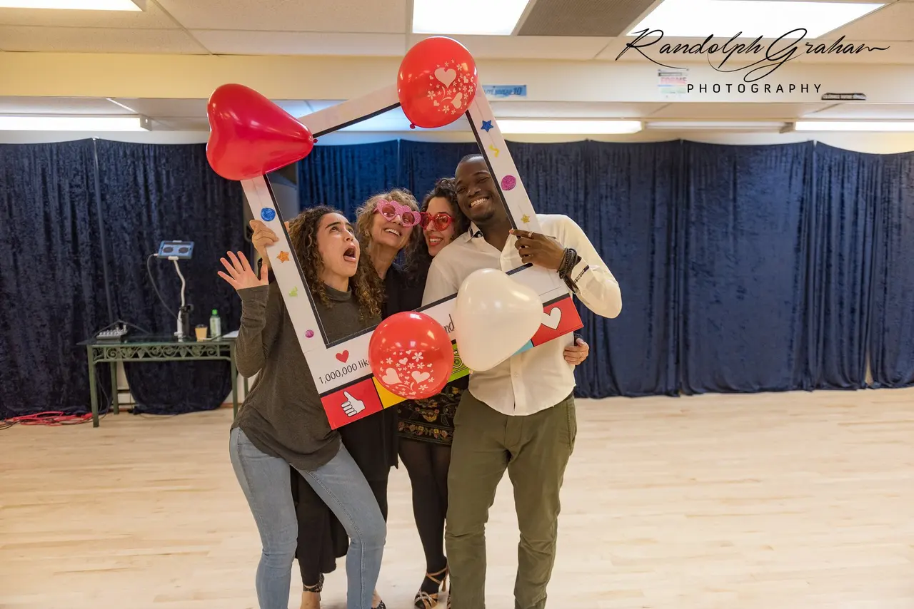 Baggio et trois autres personnes posent en tenant un cadre décoré de ballons.